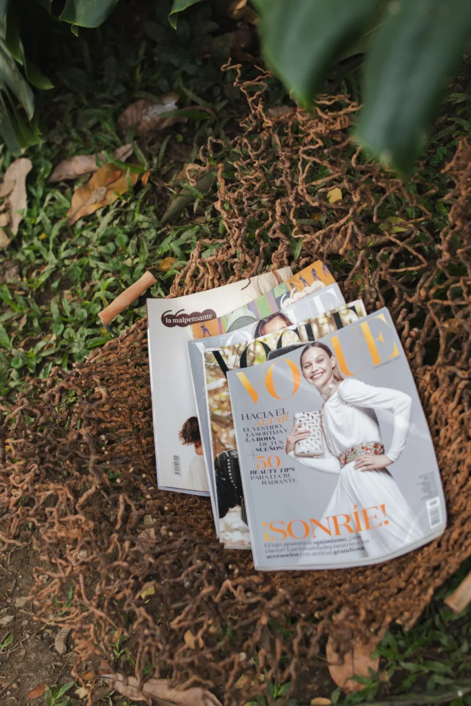 Revistas Vogue apoyadas en cesta artesanal de fibra en entorno natural – Areito Gallery